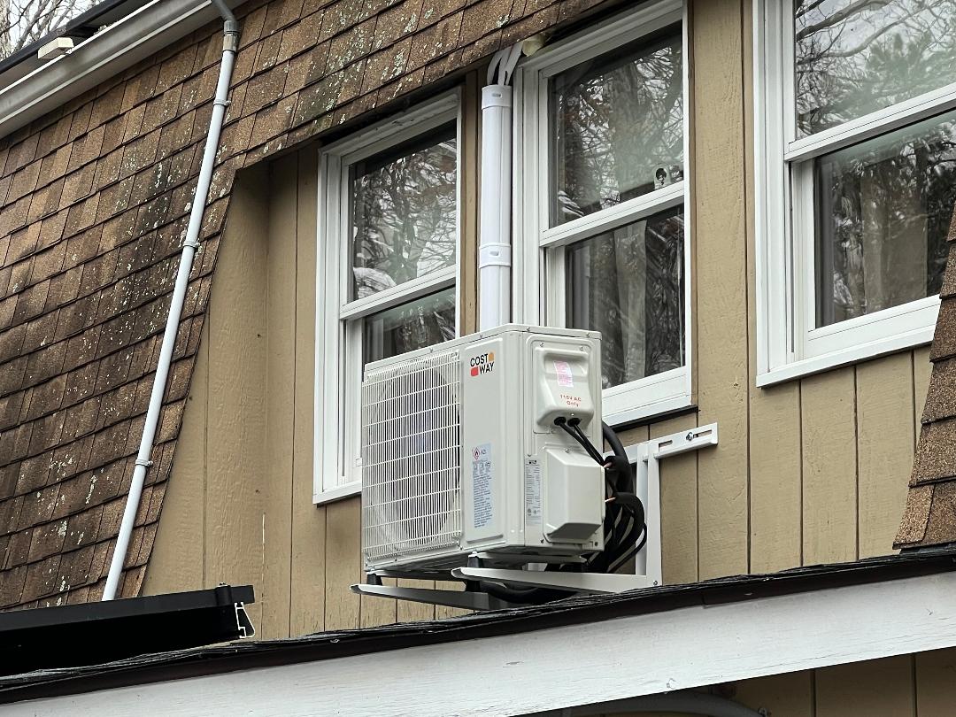 Mini-split outdoor condenser unit installed on a home